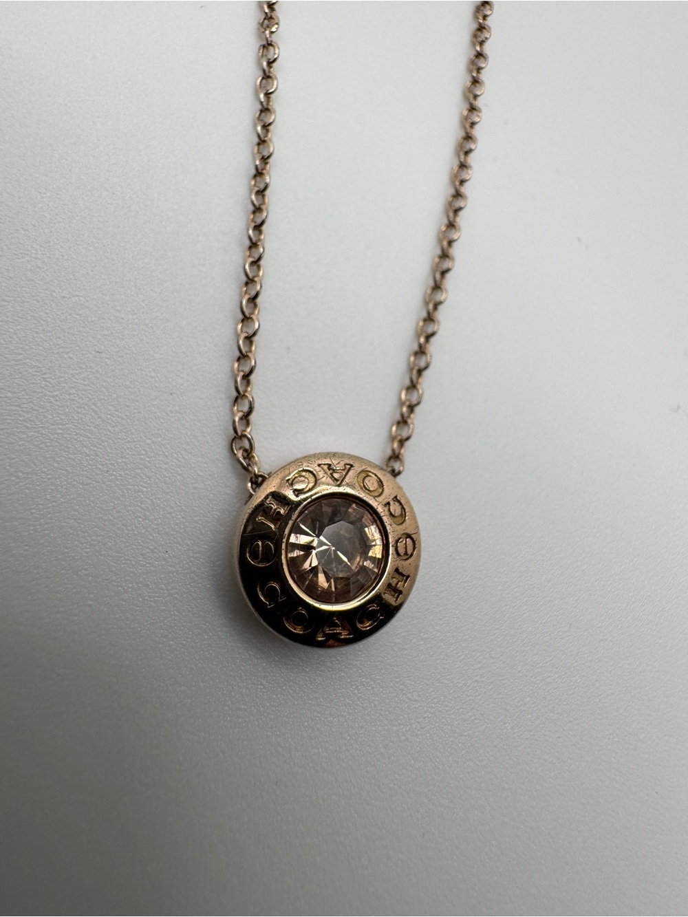Coach Rose Gold-toned Open Circle Rose-Amber Crystal Round Logo Pendant Necklace